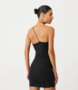 Vestido corto negro de jersey con escote de un solo hombro y tirante fino cruzado. Presenta fruncidos en la espalda.