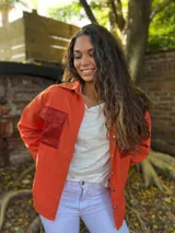 Campera de gabardina color naranja, con bolsillos delanteros y corte regular.