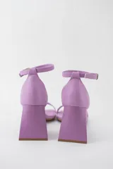 Sandalias negras de cuero sintético con punta cuadrada, tira delgada sobre los dedos y pulsera con hebilla al tobillo. Taco geométrico triangular. Marca Trend.