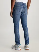 Pantalón de jean slim fit azul medio vintage, con talle bajo, cinco bolsillos y cierre con cremallera.