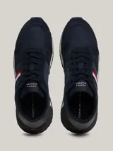 Zapatillas Tommy Hilfiger de estilo running, color azul marino con detalles en rojo, blanco y gris. Confeccionadas en poliéster con interior de poliéster, plantilla extraíble de goma termoplástica y poliuretano, y suela de goma dentada. Presentan cinta distintiva en el lateral, paneles con mezcla de texturas y parche con logo en la lengüeta.