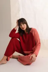 Sweater tejido a dos colores, rojo y salmón, con cuello redondo y mangas largas.