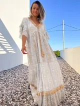 Vestido túnica largo de color celeste con bordados dorados y detalles de encaje en el escote y ruedo.