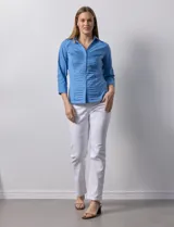 Camisa blanca de algodón marca Zac & Rachel, con cuello con solapa, abertura central con botones, delantera tableada y laterales elastizados.