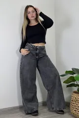 Pantalón jean gris oscuro de tiro medio, corte amplio y estilo baggy.