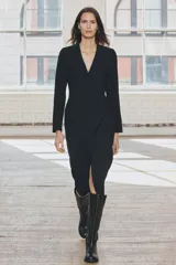 Vestido midi negro de escote pico y manga larga con hombreras. Tiene falsos bolsillos de vivo en el delantero y cierre en la espalda con cremallera oculta.