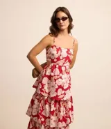 Vestido midi evasé con breteles finos ajustables, escote recto, recortes abiertos laterales, capas superpuestas en volados y estampa floral.