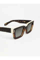 Lentes de sol Tiwi modelo Kobe, con montura gruesa de acetato color carey y lentes degradadas en tono verde.