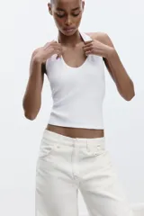 Top color crema con cuello halter y escote redondo. Espalda descubierta.