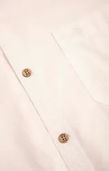Camisa amarilla de algodón orgánico, manga larga con botones de madera, cuello italiano, calce regular, bolsillo de pecho con logo bordado.