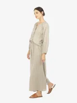 Pantalón palazzo de lino y rayón a rayas verticales en tonos beige, gris y amarillo. Tiene cintura elastizada con lazo ajustable.