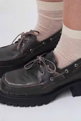 Zapato mocasín de cuero negro con cordones, plataforma y taco cuadrado.