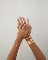 Brazalete ancho de bronce macizo con textura irregular.