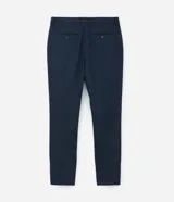 Pantalón de vestir azul marino, de corte recto, con bolsillos laterales y traseros. Se ajusta a la cintura con cinturón de cuero marrón.