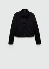 Chaqueta corta negra con cuello camisero, cierre frontal con botones, dos bolsillos laterales y forro interior.