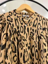 Camisa color camel con estampado animal print en negro, cuello mao y mangas largas con puños abotonados.