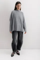 Sweater gris de punto con cuello alto y diseño de líneas horizontales en relieve.