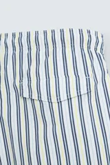 Bañador de hombre confeccionado en tejido técnico con textura. Diseño a rayas verticales en tonos azul y blanco. Cintura elástica ajustable con cordón. Bolsillos laterales y detalle de bolsillo trasero de solapa. Bajo con aberturas laterales. Forro interior.