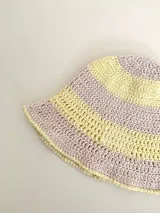 Sombrero tipo bucket tejido a crochet a mano, con hilo 100% algodón y diseño a rayas en tonos rosa y rojo. Presenta una etiqueta con el logo de la marca Cilento en el frente.