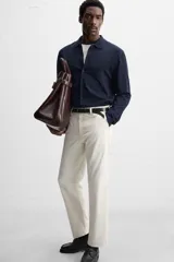 Pantalón chino negro slim fit confeccionado en tejido técnico de secado rápido. Cuenta con bolsillos frontales y traseros de vivo. Cierre frontal con cremallera y botón.