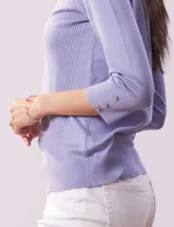 Sweater lila de tejido combinado, con cuello redondo y mangas 3/4 con detalle de botones.