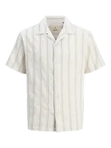 Camisa de manga corta con cuello resort y cierre de botones. Confeccionada en tejido dobby con mezcla de algodón y lino.