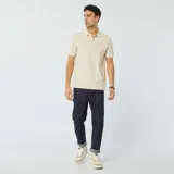 Chomba de piqué de algodón color beige con cuello clásico y tapeta de dos botones.