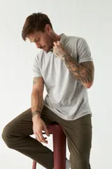 Remera con cuello tipo polo en gris claro, con logo bordado y manga corta.