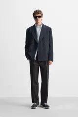 Pantalón de vestir negro de corte recto, con cintura elástica, pliegues frontales, bolsillos laterales y traseros.