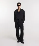 Camisa negra de poliéster con cuello inglés, manga larga, abotonada adelante y textura con rayas verticales.