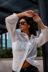 Camisa color beige con bordado inglés, de corte recto, manga larga abullonada con puño y cuello camisero.