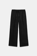 Pantalón negro de tiro medio con bolsillos delanteros y traseros. Cintura elástica ajustable con cordones.
