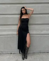 Vestido largo negro strapless con frunce en el busto, tajo lateral y lazo en la cintura. Incluye choker.