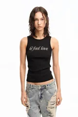 Musculosa blanca de algodón con cuello redondo y estampado frontal con la frase "I feel love" en letras cursivas negras con strass.