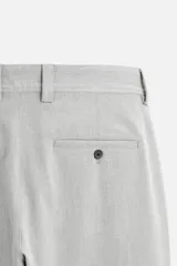 Pantalón slim fit negro confeccionado en tejido con elasticidad en ambas direcciones. Cuenta con bolsillos frontales y traseros de vivo con botón. Cierre frontal con cremallera y botón.