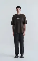 Remera negra con efecto gastado, cuello redondo y estampado frontal con la palabra 'AMOR' en blanco.