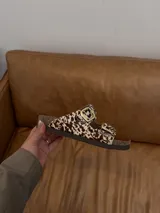 Sandalias con estampado animal print de vaca, con dos hebillas doradas ajustables, plantilla anatómica y suela tipo Birkenstock.