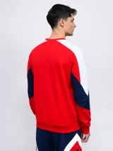 Buzo de felpa azul marino, con mangas largas, cuello redondo y puños acanalados. Presenta cortes en blanco y rojo en la parte superior, logo de Umbro bordado en el pecho y escudo del Club Nacional de Football.