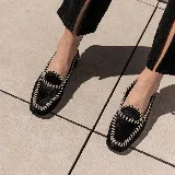 Mocasines negros de cuero vacuno con tientos de cuero pasados a mano y suela de goma.