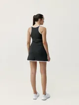 Vestido deportivo negro con ribetes blancos, escote redondo, breteles finos y falda corta con abertura lateral.