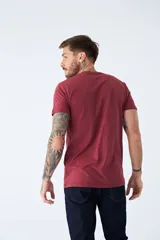 Remera de algodón color bordó con estampado rectangular azul con letras blancas en el frente.