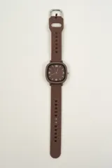 Reloj de pulsera negro con caja cuadrada y correa de silicona con hebilla.