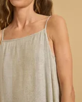 Vestido largo color beige con brillo, de tirantes finos y corte amplio.