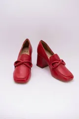 Zapato clásico de cuero azul marino, con aplique decorativo en el empeine y taco cuadrado.