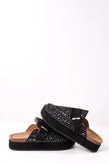 Zueco negro con plataforma, tachas plateadas y hebilla ajustable.