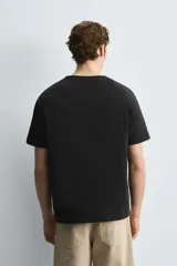 Camiseta verde militar de corte holgado confeccionada en tejido de algodón compacto. Cuello redondo con ribete doble y mangas cortas.
