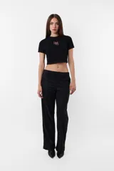 Remera corta negra tipo baby tee de algodón con cuello redondo y costuras rojas. Estampa de corazón con flecha en el frente.