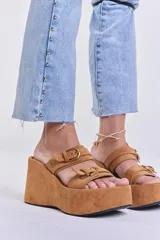 Sandalias color camel con plataforma tipo flatform y dos tiras anchas con hebillas doradas.