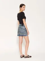 Minifalda de denim con lavado irregular, localizados y desgastes estratégicos. Su superficie presenta un coating especial que genera un acabado simil cuero.