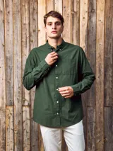 Camisa de manga larga color verde militar, confeccionada en tejido Oxford 100% algodón. Tiene cuello abotonado, cierre con botones y un bolsillo en el pecho. Corte slim fit.